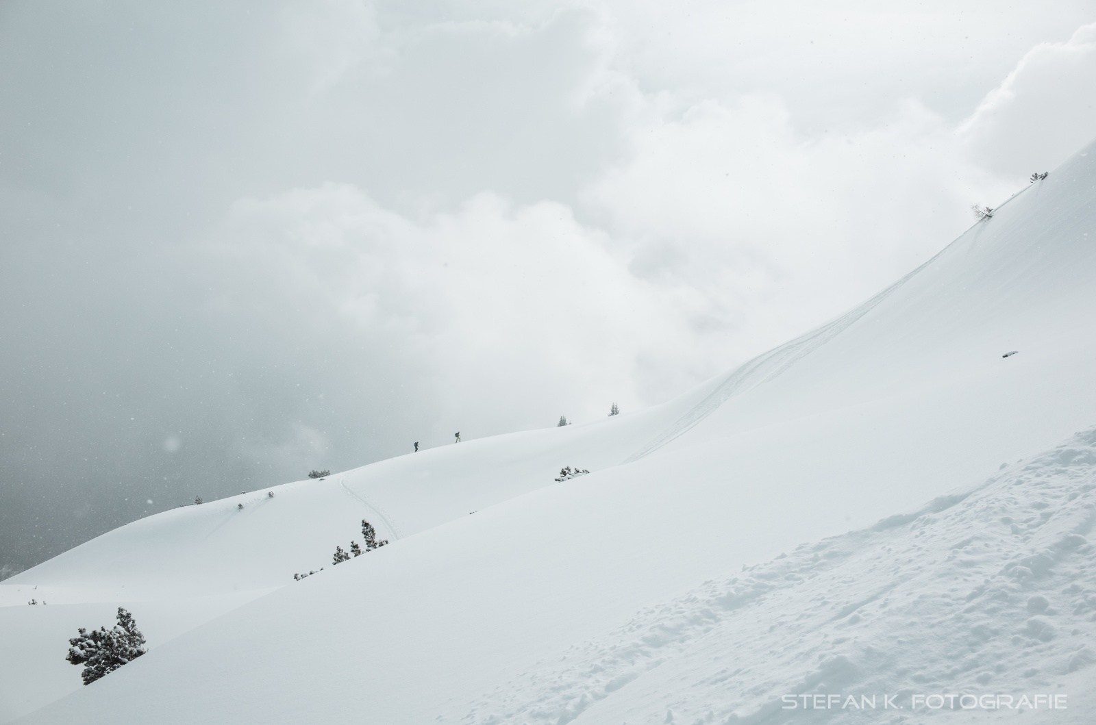 zwei Skitouristen beim Aufstieg zum Gipfel